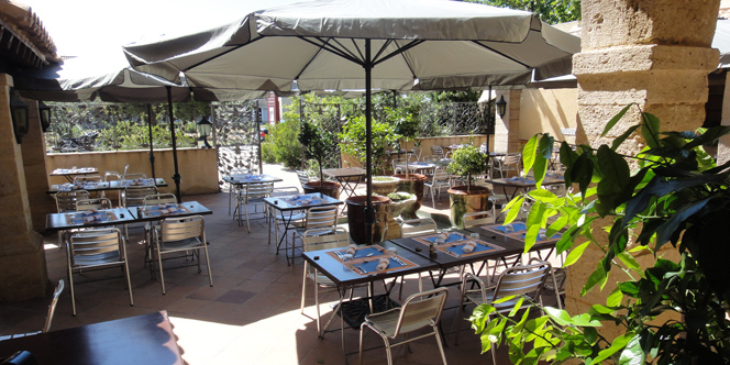 Restaurant Les Cuisiniers Vignerons Lattes propose des tables en terrasse en automne.